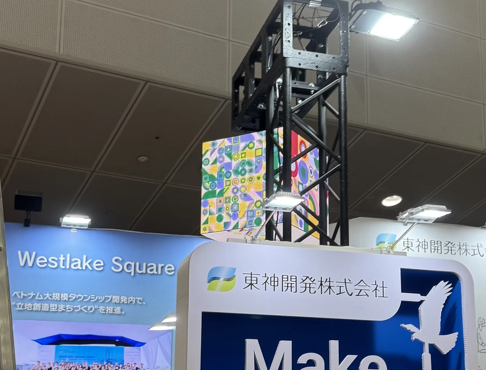 展示会ブースのトラスの上部に、キューブ型のLEDビジョンを吊り下げて設置した施工事例